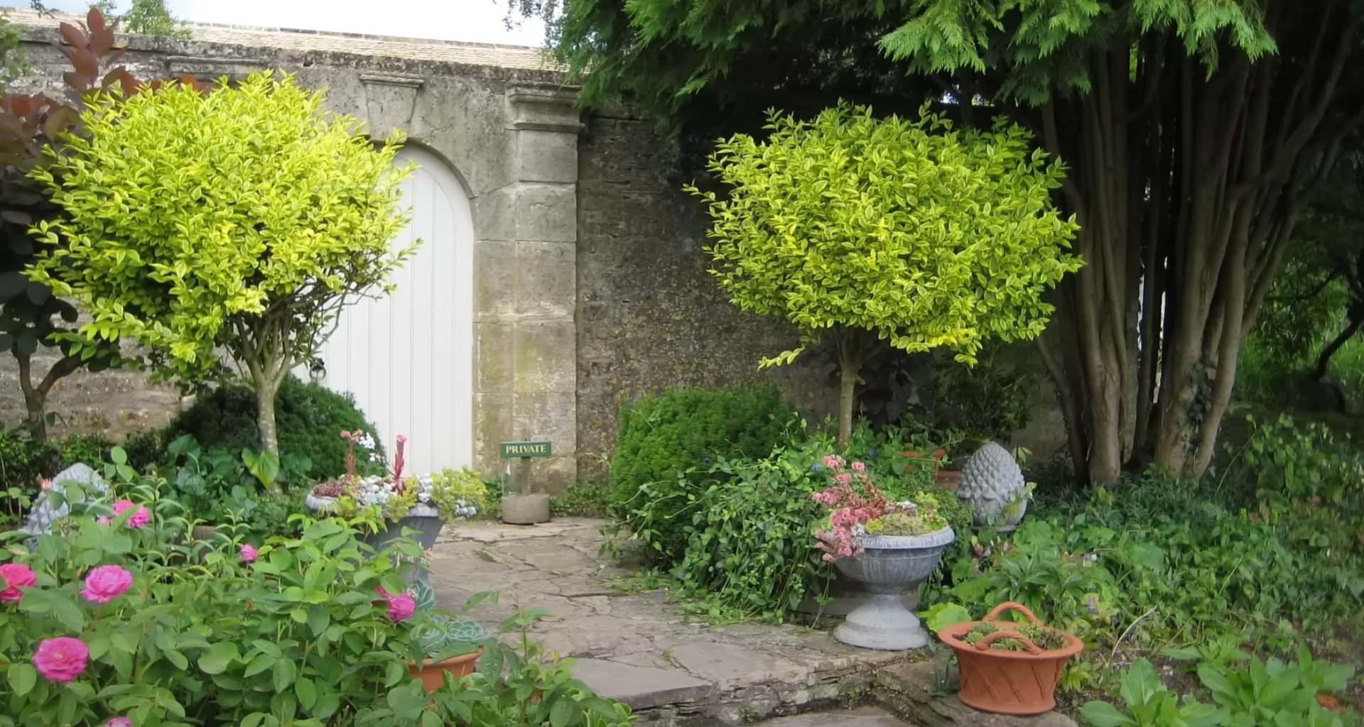 Elegant garden entrance with stone archway and lush plantings