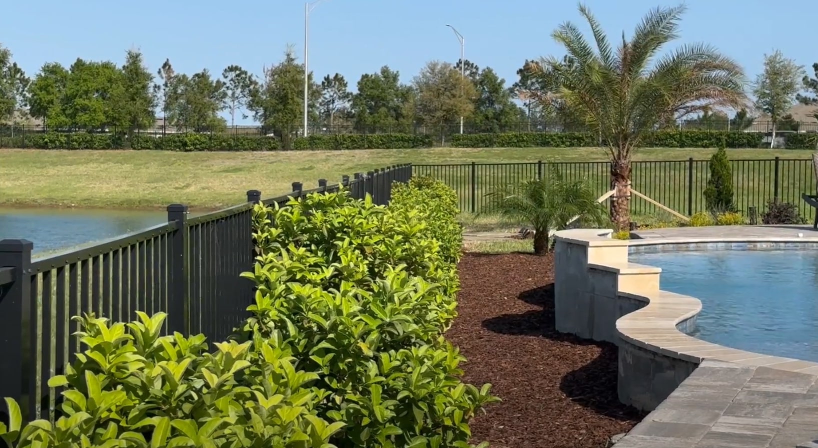 Beautiful backyard with pool, fence, and professional landscaping design